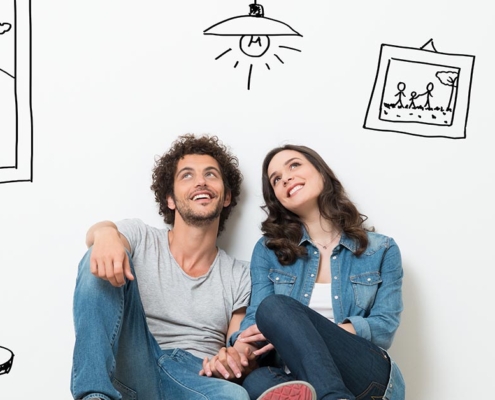Glückliches Paar sitzt auf dem Boden in einem gezeichneten Haus | Notverkauf
