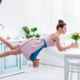 Junge elegante Frau schwebt barfuß mit Tulpen in der Luft in einem Haus