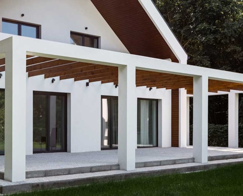 Eine Terrasse mit weißer Pergola und Garten - Immobilienkauf