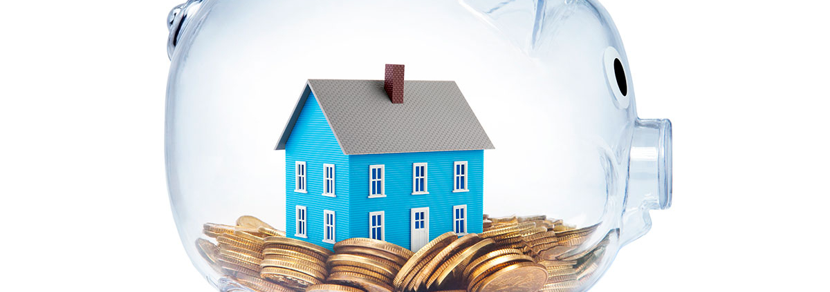 Ein gläsernes Sparschwein mit einem Häuschen und Münzen drin - Checkliste Immobilienfinanzierung