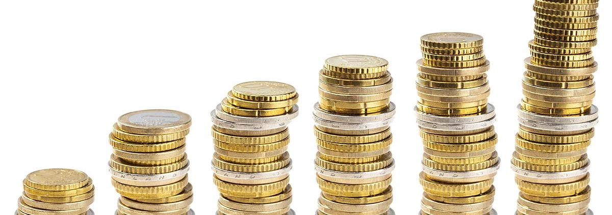 Verschiedene Euromünzen sind zu Türmen gestapelt, die Türme werden von links nach rechts höher | Förderung Immobilienkauf