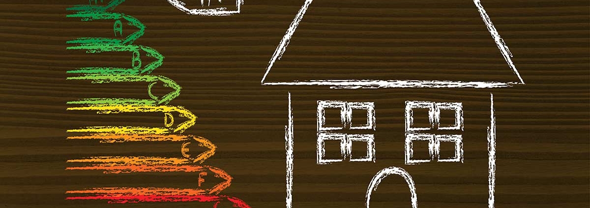 Auf einen Holztisch sind mit Kreide ein Haus und links daneben die Energieeffizienzklassen gemalt | Energetische Sanierung