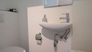 Im GästeWC befindet sich ein Einbauschrank für Waschmaschine und Trockner